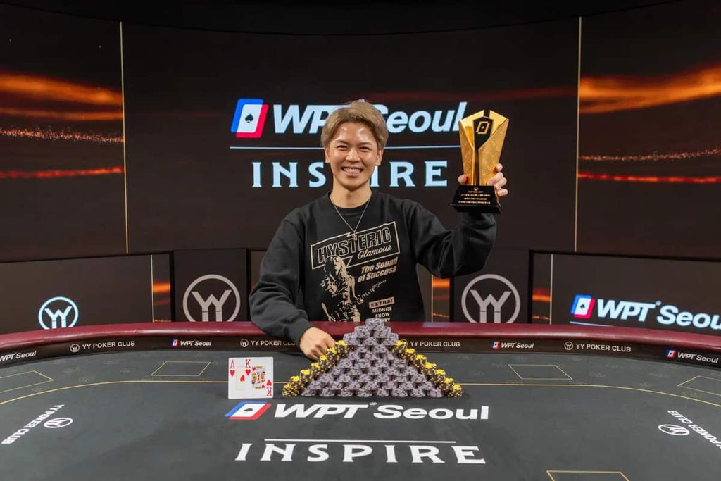 Daisuke Nagano celebrates winning the WPT Seoul 2026 Inspire Superstack, holding his trophy behind a stack of poker chips and his winning ace-king hand.