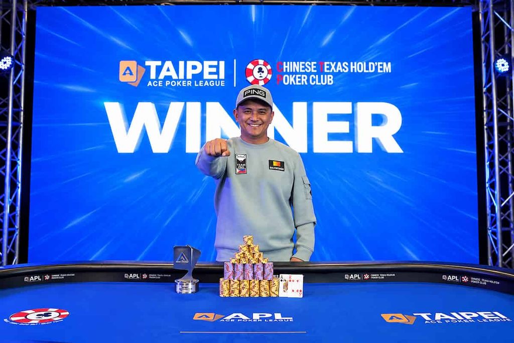 Lester Edoc celebrates his 2026 Taiwan Millions Tournament Main Event victory in Taipei, posing behind stacks of poker chips and his winner's trophy.