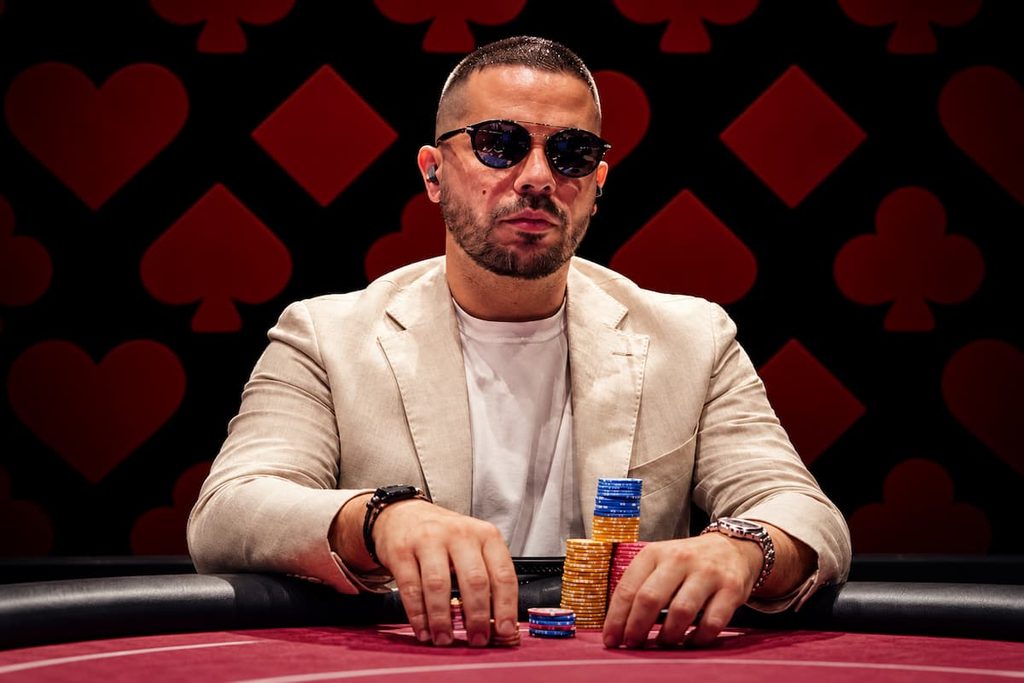 Colombian poker pro Farid Jattin at the poker table with stacks of chips after signing as Stake Poker's first ambassador.
