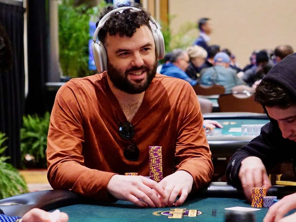 Poker player Matthew Wantman at the table wearing over-ear headphones.
