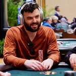 Poker player Matthew Wantman at the table wearing over-ear headphones.